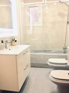 a bathroom with a toilet and a sink and a tub at Apartamento Cartellà 3 habitaciones in Barcelona