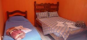 a bedroom with two twin beds with clothes on them at Pousada Labarca in Cachoeira