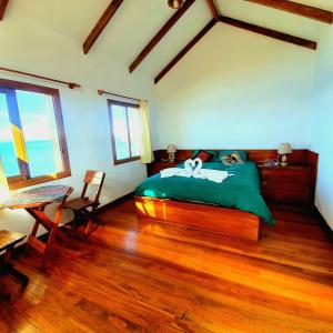 a bedroom with a green bed and a wooden floor at Ecolodge El descanso in Comunidad Yumani