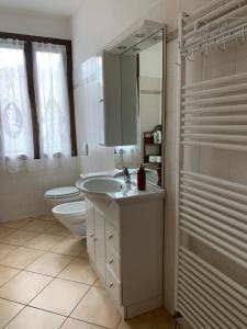 a bathroom with a sink and a toilet and a mirror at Appartamenti Sole e Lago in Gravedona +23 photos
