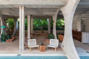 a patio with two chairs and a swimming pool at Casa TO in Puerto Escondido