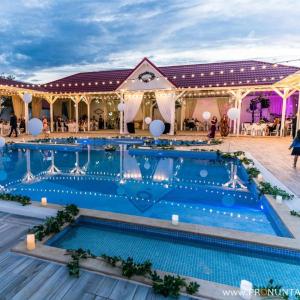 a large pool with blue water in front of a building at Pensiunea Ramina in Adjud