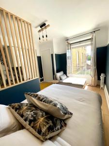 a bedroom with two beds and a large window at Hyper centre idéal gare Amiens in Amiens