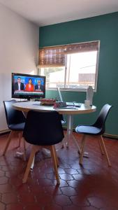 a room with a desk with two chairs and a computer at Departamento San Lorenzo para 4 personas in Mendoza
