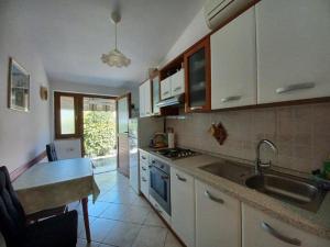- une cuisine avec des placards blancs, un évier et une table dans l'établissement Apartments by the sea Novigrad - 7335, à Novigrad