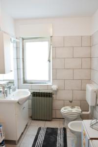 baño con lavabo y aseo y ventana en FoREST Heritage Apartment, en Hreljin