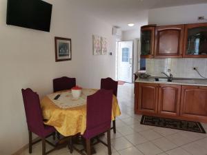 a kitchen with a table with purple chairs and a sink at Apartments by the sea Cove Mikulina Luka, Korcula - 9181 in Vela Luka