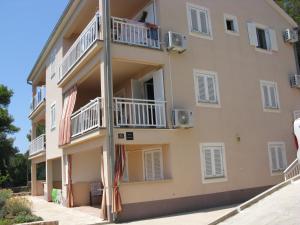 un gran edificio de apartamentos con balcones y sombrillas en Apartment Sveta Nedilja 14086a, en Jelsa