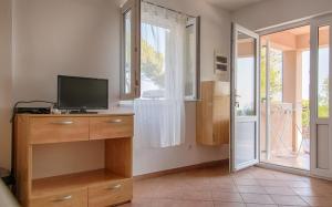 ein Wohnzimmer mit einem TV und einem Fenster in der Unterkunft Apartment Sveta Nedilja 14086a in Jelsa