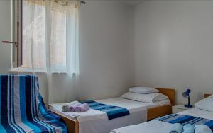 two beds in a small room with a window at Apartment Sveta Nedilja 14086b in Jelsa