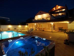 a house with a swimming pool at night at Apartments and rooms with a swimming pool Kali, Ugljan - 14083 in Kali