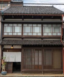 an asian house with windows and a roof at Machiya Guest House Carta in Kanazawa