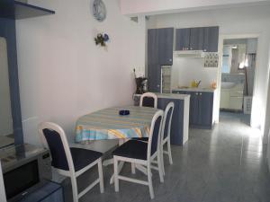 a small kitchen with a table and chairs in a room at Apartments with a parking space Lopar, Rab - 14089 in Lopar