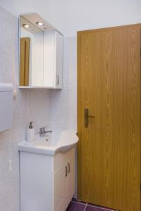 bagno con lavandino e porta in legno di Studio Zuronja 14095b a Putniković