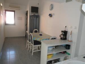 a kitchen and dining room with a table and a refrigerator at Apartments with a parking space Lopar, Rab - 14089 in Lopar
