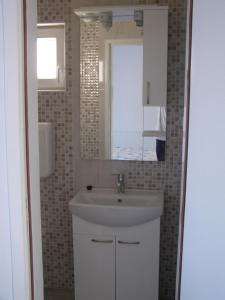 La salle de bains est pourvue d'un lavabo et d'un miroir. dans l'établissement Secluded fisherman's cottage Cove Picena, Korcula - 14090, à Vela Luka