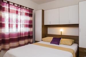 una camera con due letti e un cuscino viola di Apartments by the sea Zuronja, Peljesac - 14095 a Putniković