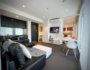 - un salon avec un canapé en cuir noir et une table dans l'établissement Luxury 2 Bedroom Suite near Adelaide with a car park, à Broadview