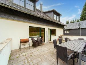 a patio with a wooden table and chairs at Forest Escape with Terrace in Eisfeld