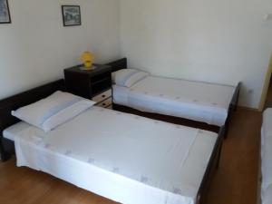 Zimmer mit 2 Betten und einem Tisch mit einer Lampe in der Unterkunft Apartments with a parking space Banjol, Rab - 14138 in Rab