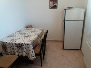 ein Esszimmer mit einem Tisch und einem Kühlschrank in der Unterkunft Apartments with a parking space Banjol, Rab - 14138 in Rab