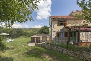 una casa con cortile, tavolo e panca di Holiday house with a parking space Mali Turini (Central Istria - Sredisnja Istra) - 14136 a Labin