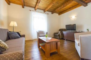 een woonkamer met een bank en een tafel bij Holiday house with a parking space Mali Turini (Central Istria - Sredisnja Istra) - 14136 in Labin