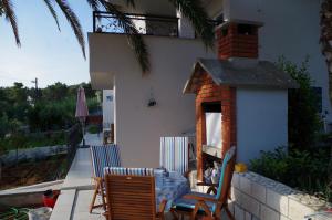 a patio with a table and chairs and a fireplace at Apartments by the sea Slatine, Ciovo - 14158 in Slatine