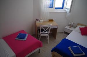 a bedroom with two beds and a desk with a chair at Apartments by the sea Slatine, Ciovo - 14158 in Slatine