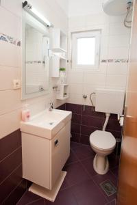 uma casa de banho com um WC branco e um lavatório. em Apartments with a swimming pool Preko, Ugljan - 14163 em Preko