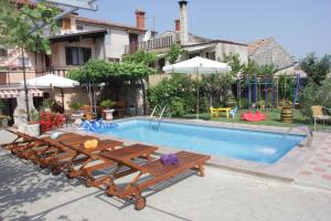 a swimming pool with a group of benches next to it at Family friendly apartments with a swimming pool Vodnjan, Fazana - 14159 in Vodnjan