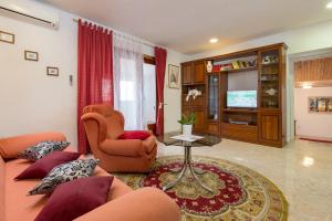 a living room with a couch and a chair and a television at Family friendly apartments with a swimming pool Vodnjan, Fazana - 14159 in Vodnjan