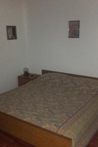 a bed in a bedroom with two pictures on the wall at Apartments by the sea Cove Pogana, Cres - 14172 in Nerezine