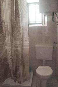 a bathroom with a toilet and a window at Apartments by the sea Cove Pogana, Cres - 14172 in Nerezine