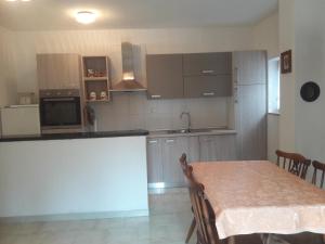 a kitchen with a table and a counter top at Apartments by the sea Cove Pogana, Cres - 14172 in Nerezine