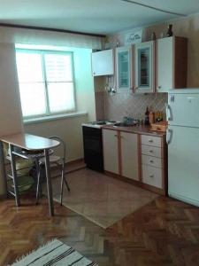 a kitchen with a table and a white refrigerator at Apartments by the sea Razanac, Zadar - 14179 in Ražanac