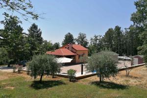 une maison avec des arbres devant elle dans l'établissement Family friendly house with a swimming pool Lindar, Central Istria - Sredisnja Istra - 14189, à Pazin