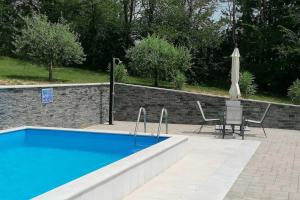 - une piscine avec un parasol, une table et des chaises dans l'établissement Family friendly house with a swimming pool Lindar, Central Istria - Sredisnja Istra - 14189, à Pazin