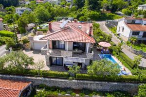 - une vue aérienne sur une maison avec une piscine dans l'établissement Apartments with a swimming pool Lovran, Opatija - 14196, à Lovran