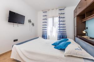 Un dormitorio con una cama con almohadas azules. en Apartments with a swimming pool Lovran, Opatija - 14196, en Lovran