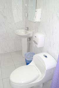 een witte badkamer met een toilet en een wastafel bij Comodas Habitaciones Hotel Bucaros in Espinal