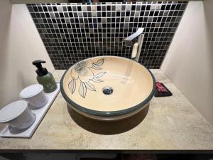 a sink with a flower painted on it on a counter at Gion Misen in Kyoto
