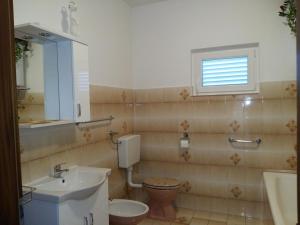 La salle de bains est pourvue d'un lavabo, de toilettes et d'une fenêtre. dans l'établissement Apartments with a parking space Vrsi, Zadar - 14211, à Vrsi