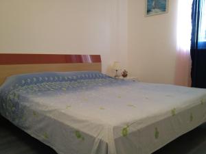 1 dormitorio con 1 cama con edredón azul en Family friendly apartments with a swimming pool Razanj, Rogoznica - 14232 en Rogoznica