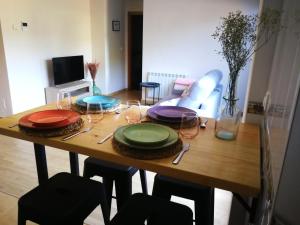 una mesa de madera con platos y copas de vino. en Ático O Rial, en Puentecesures