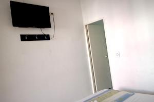 a room with a mirror and a tv on the wall at Comodas Habitaciones Hotel Bucaros in El Espinal