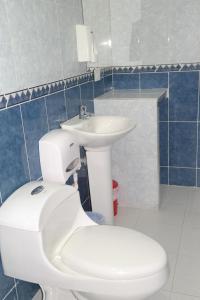 een badkamer met een wit toilet en een wastafel bij Comodas Habitaciones Hotel Bucaros in Espinal