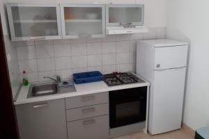 a small kitchen with a stove and a refrigerator at Seaside secluded apartments Cove Vele Gacice, Hvar - 14255 in Bogomolje