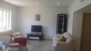 - un salon avec deux chaises blanches et une télévision dans l'établissement Apartment Marina 14258a, à Marina