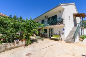 ein weißes Haus mit einer Treppe und einem Baum in der Unterkunft Apartments with a parking space Marina, Trogir - 14258 in Marina